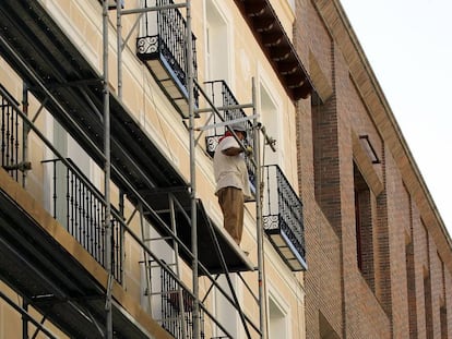 Un hombre trabaja en la rehabilitaci&oacute;n de una fachada en Madrid