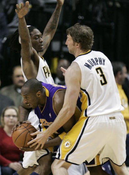 Kobe Bryant se cuela entre dos defensores de los Pacers