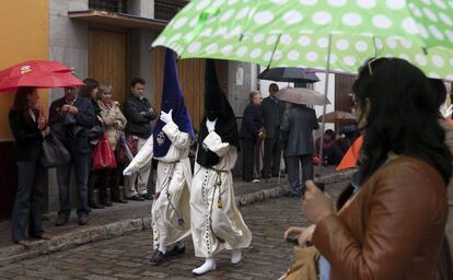 Two members of an Easter procession parade in the rain in Seville in 2012.