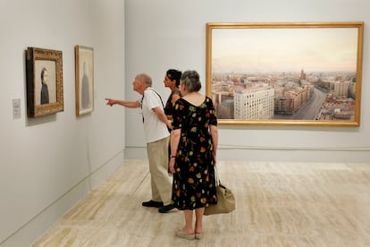 El pintor, junto a su esposa María y una de sus hijos, señala uno de los cuadros que componen la exposición en el Museo Thyssen-Bormemiza de Madrid.