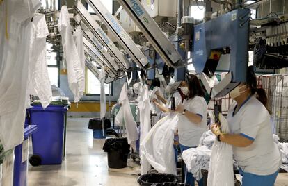 Vista de las instalaciones de la lavandería Ilunion, un enorme centro de desinfección, lavado y planchado, a las afueras de Madrid, donde varias decenas de hombres y mujeres, la mayoría con alguna discapacidad, afrontan la avalancha de 30.000 kilos de uniformes, batas, sábanas y toallas que provienen diariamente los hospitales de Madrid.