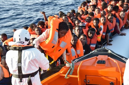 Un miembro de la ONG maltesa MOAS ayuda a una mujer a subir a bordo de un bote de rescate. 