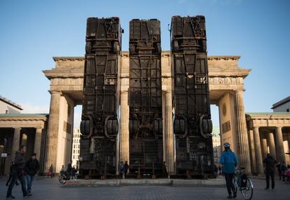 Vista de la obra 'Monument', del artista alemán de origen sirio Manaf Halbouni, delante de la Puerta de Brandenburgo en Berlín (Alemania). La pieza esta compuesta de tres autobuses y recuerda a las barreras formada por estos vehículos en las calles de la ciudad siria de Alepo para proteger a la población civil de los francotiradores. Esta obra forma parte de la iniciativa artística 'Herbstsalon', que se celebra este mes en la capital alemana.