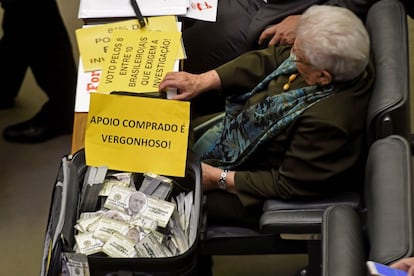 A deputada Luiza Erundina, da oposição, com uma mala cheia de dólares falsos, com imagens de Michel Temer, em protesto contra o presidente. A mala é uma referência ao ex-assessor do presidente, o deputado Rodrigo Rocha Loures, que ficou conhecido como o "homem da mala" e foi preso pela Lava Jato. 