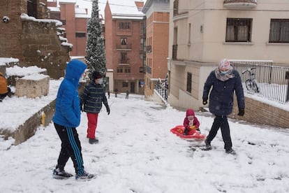 Los niños juegan en el casco viejo de Huesca con la nieve este sábado, en el que la Península sigue afectada por el temporal 'Filomena'.