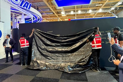Personal del Salón Internacional de Aeronáutica y del Espacio de Le Bourget, la mayor feria del sector, cubre con una lona un mensaje político a favor de Israel escrito por una trabajadora.
