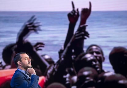 El ministro de Interior italiano, Matteo Salvini, frente a una fotografía de migrantes siendo rescatados en el mar. 