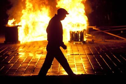 Un hombre pasa una barricada de fuego hoy en Bucarest (Rumanía).