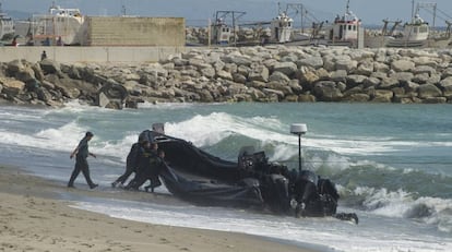 Guardias civiles empujan una lancha utilizada por los narcos en el Estrecho.