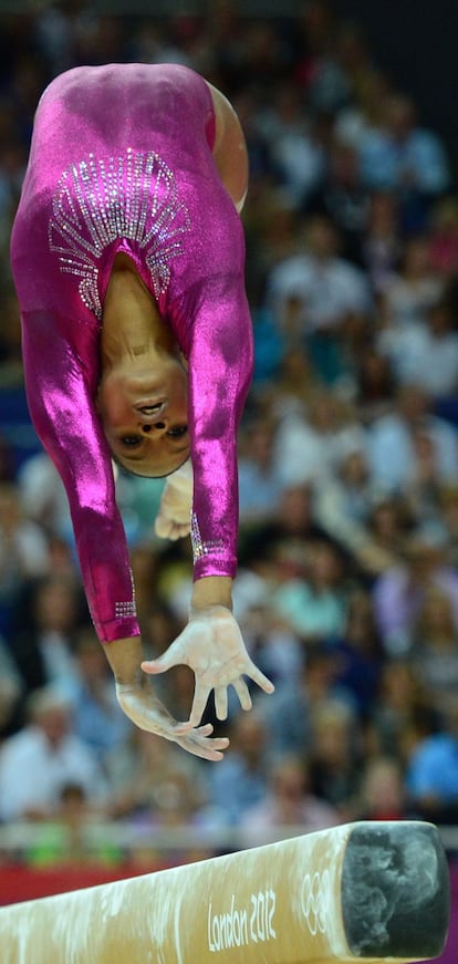 La ganadora del oro Gabrielle Douglas saltando en la barra de equilibrio.