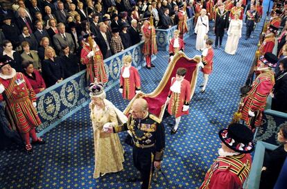 La reina Isabel II de Inglaterra acompañada por su esposo el Duque de Edimburgo, en procesión oficial por la Royal Gallery (Galería Real), camino de la Cámara de los Lores, en Londres (Reino Unido), donde presidió la apertura del año parlamentario, el 13 de noviembre de 2002.
