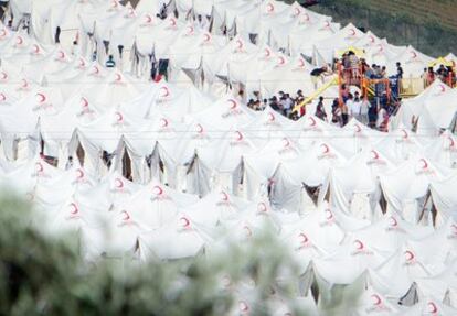 Un grupo de niños sirios refugiados en uno de los campamentos de la Media Luna Roja en la frontera con Turquía usan el área de juegos del campamento.