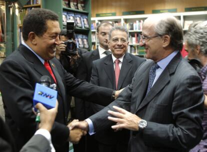 El presidente de Venezuela, Hugo Chávez, saluda al presidente de Repsol, Antonio Brufau, en la Casa del Libro en la Gran Vía.