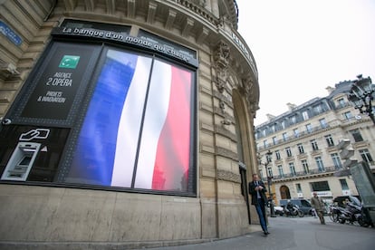  Un pantalla digital con los colores de la bandera de Francia, en el banco BNP en la Plaza de la Ópera de Paris.