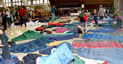 Niños desalojados de una campamento, refugiados en el polideportivo de Benasque.