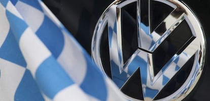 Una bandera de cuadros azules y blancos, reflejada sobre la insignia de un coche Volkswagen