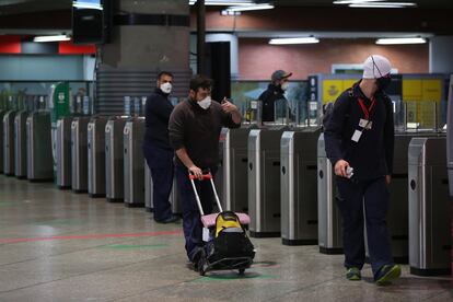 Varios viajeros con mascarilla atraviesan los tornos en la estación de Atocha, el 14 de mayo.