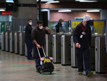 Varios viajeros con mascarilla atraviesan los tornos en la estación de Atocha, el 14 de mayo.