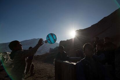 Niños afganos juegan con un balón cerca de un mercado animal en Kabul (Afganistán). 