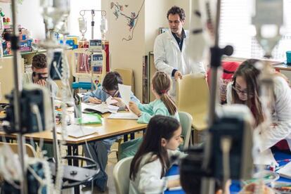 Eduardo Velay, uno de los maestros del hospital, durante una clase con niños ingresados. En sus palabras, procura que los críos no pierdan el curso escolar, y puedan tener “un rincón de normalidad. ”