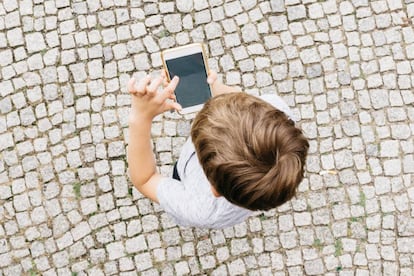 Un niño juega con un móvil.