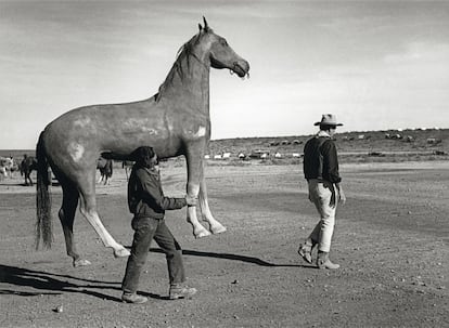 La imagen del vaquero John Wayne, inmortalizada en 1959 durante el rodaje de El &Aacute;lamo. Detr&aacute;s, un atrezista con un caballo de cart&oacute;n piedra a la medida del actor. 