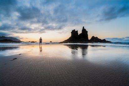 Playa de Benijo (Tenerife). El de Benijo es uno de los arenales más espectaculares de las islas Canarias, una playa salvaje en estado natural. Escoltado por el roque Benijo y el roque La Rapadura, es una de las playas más fotogéni­cas de todo el archipiélago. Sus arenas negras se extien­den en la costa norte de Teneri­fe, en la zona de Anaga, y es muy poco transitada por el turismo, por lo que se ha conservado salvaje, sin equipar, como una especie de templo local para re­cordar la belleza masiva de estos entornos volcánicos tan melan­cólicos como enérgicos.