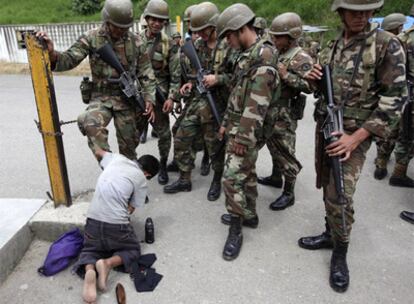 Un soldado se hace limpiar las botas en el paso de Las Manos.