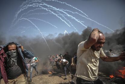 Varios palestinos corren para refugiarse de un ataque de las fuerzas israelíes en la frontera de Gaza, el 8 de junio.