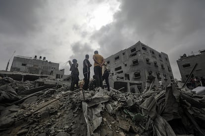 Residentes palestinos buscan supervivientes en los escombros de un edificio destruido por un ataque israelí en el campo de refugiados de Al Nuseirat, en el sur de Gaza.