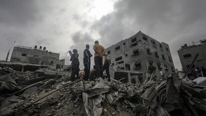 Residentes palestinos buscan supervivientes en los escombros de un edificio destruido por un ataque israelí en el campo de refugiados de Al Nuseirat, en el sur de Gaza.