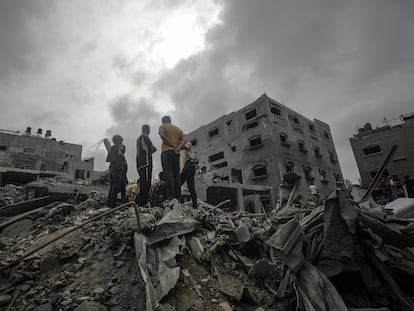 Residentes palestinos buscan supervivientes en los escombros de un edificio destruido por un ataque israelí en el campo de refugiados de Al Nuseirat, en el sur de Gaza.