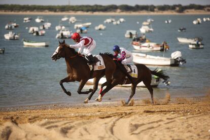 Carrera de caballos al atardecer en la playa de Sanlúcar der Barrameda (Cádiz), una tradición que cumple 170 años y reúne anualmente a miles de visitantes.