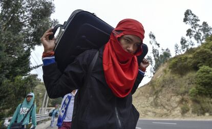 Un hombre venezolano carga una maleta camino de Perú en la carretera de Tulcan (Ecuador).