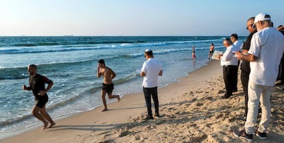 Israelíes religiosos rezan en el año nuevo judío mientras otros corren en una playa de Ashdod.