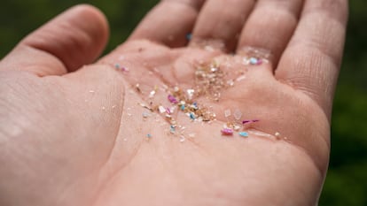 Detalle de una mano con diminutos trozos de plástico.