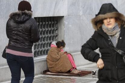 Una mujer mendiga en las calles de Atenas pese a las bajas temperaturas.