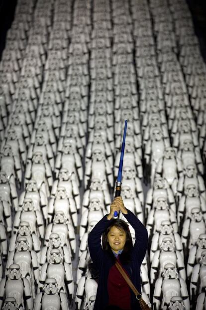 Una fan de la película 'La guerra de las galaxias' posa con una pistola láser delante de cientos de soldados del ejército imperial en la Gran Muralla china, con motivo del estreno de la nueva película.