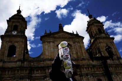 Un hombre vende chapas con la imagen del papa Francisco frente a la catedral de la plaza de Bolívar en Bogotá.