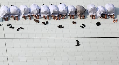 Un grupo de musulmanes se descalza para rezar ante la Kaaba en La Meca.