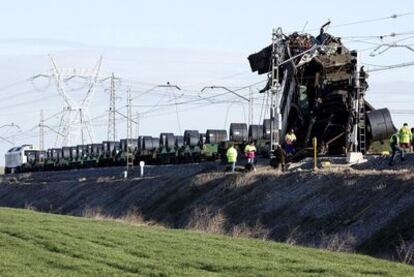 Un grupo de operarios trabaja junto a los trenes de mercancías que chocaron ayer en las cercanías de Arévalo (Ávila).