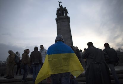 Un manifestante, con la bandera de Ucrania, asiste a una protesta convocada "Esto no es Moscú!" frente al monumento del ejército soviético en Sofía (Bulgaria).