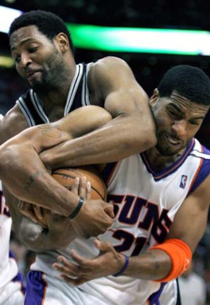 Horry, de los Spurs (izqda.) y Jackson, de Phoenix, pelean por el balón.