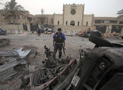 Un policía iraquí, junto al coche bomba utilizado para atentar contra una iglesia en Bagdad.