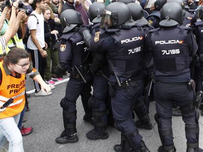 Una periodista identificada amb una armilla cobrint una c&agrave;rrega policial durant el refer&egrave;ndum il&middot;legal.