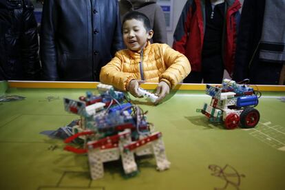 Un niño juega con un robot teledirigido. La conferencia incluye actividades de robótica también para adolescentes.