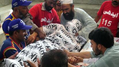 Un grupo de paquistan&iacute;es portan el cuerpo del candidato asesinado este viernes, Sadiq Zaman Khattak.