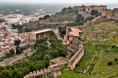 Vista del castillo de Sagunto, con el edificio techado de recepción de visitantes acabado y cerrado desde hace 11 años y el escenario del teatro Romano, abajo a la izquierda.