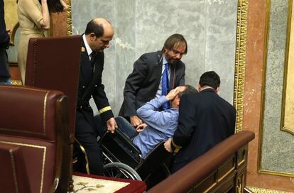 Joan Baldoví sale del hemiciclo en silla de ruedas tras sufrir un desmayo.