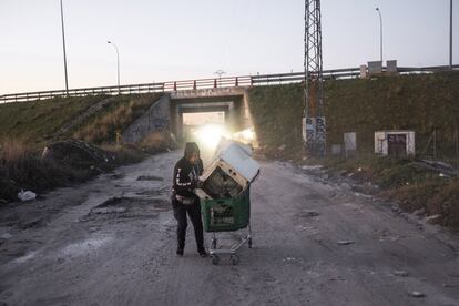 Baldomero arrastra en su carro una lavadora que tiene que llevar a primera hora a la chatarrería donde trabaja su primo. Ahora en invierno las manos se le congelan al agarrar el hierro. No puede utilizar guantes porque se le escurre el carro. Trabaja con poca ropa porque rápidamente comienza a sudar y le sobra todo. El trayecto hasta la chatarrería le obliga a pasar por un camino sin asfaltar, lleno de baches que los días de lluvia se embarra hasta dejarlo intransitable. "Yo votaría al alcalde que asfalte esto, para mí sería un regalo", afirma mientras se ríe.